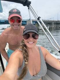 A cheerful couple enjoys a day on the water, capturing a fun moment while boating — perfect for summer adventures and romantic getaways.