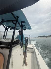 A view from the helm of a boat, showcasing the captain steering while enjoying a day on the water. Perfect for those looking to experience boating adventures.