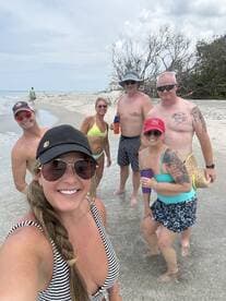 A fun group of friends enjoys a beach day, capturing memories with smiles and drinks in hand — perfect for summer outings and celebrations.