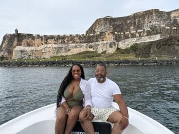 A couple enjoys a scenic boat ride with a historic fortress in the background, perfect for romantic outings and sightseeing adventures.