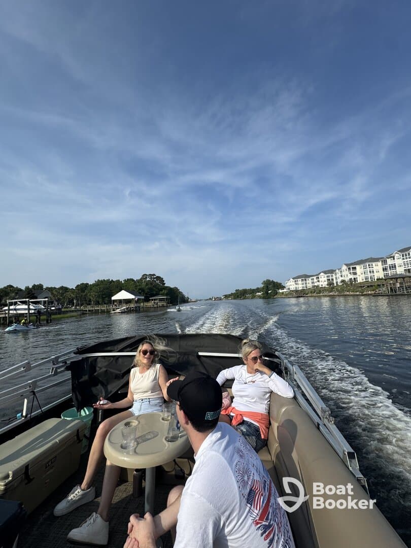 A group of friends enjoys a relaxing day on the water, sipping drinks and taking in the scenery aboard a boat — perfect for a fun outing or celebration.