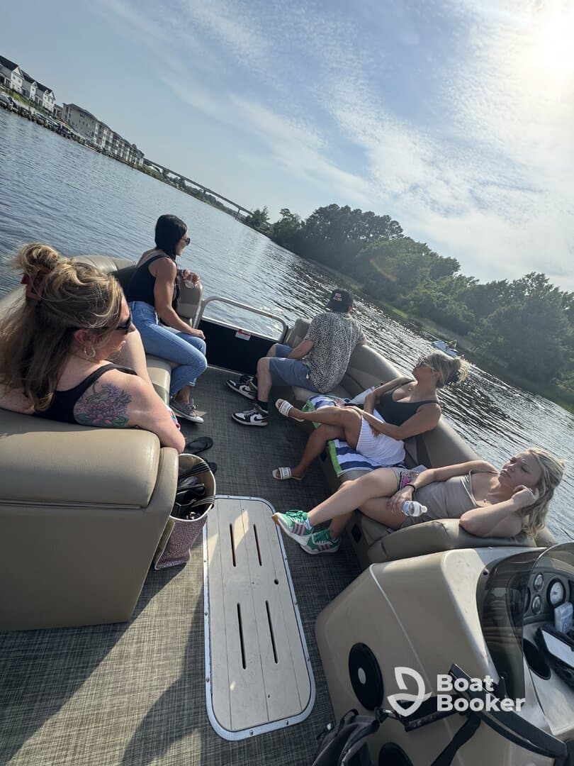 A group of friends enjoys a relaxing day on a pontoon boat, soaking up the sun and the scenic views along the waterway.