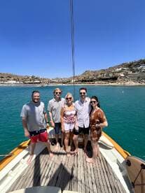 A cheerful group of friends poses together on the deck of a boat, enjoying a sunny day on the water — perfect for memorable outings and celebrations.