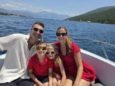 A joyful family poses together on a boat, enjoying a sunny day on the water — perfect for creating lasting memories during summer adventures.