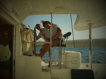 Two friends enjoy a fun moment aboard a boat, showcasing the joy of life on the water — perfect for group adventures and celebrations.
