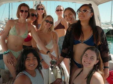 A joyful group of friends poses together on a boat, showcasing their fun day in the sun — perfect for celebrations and memorable outings on the water.