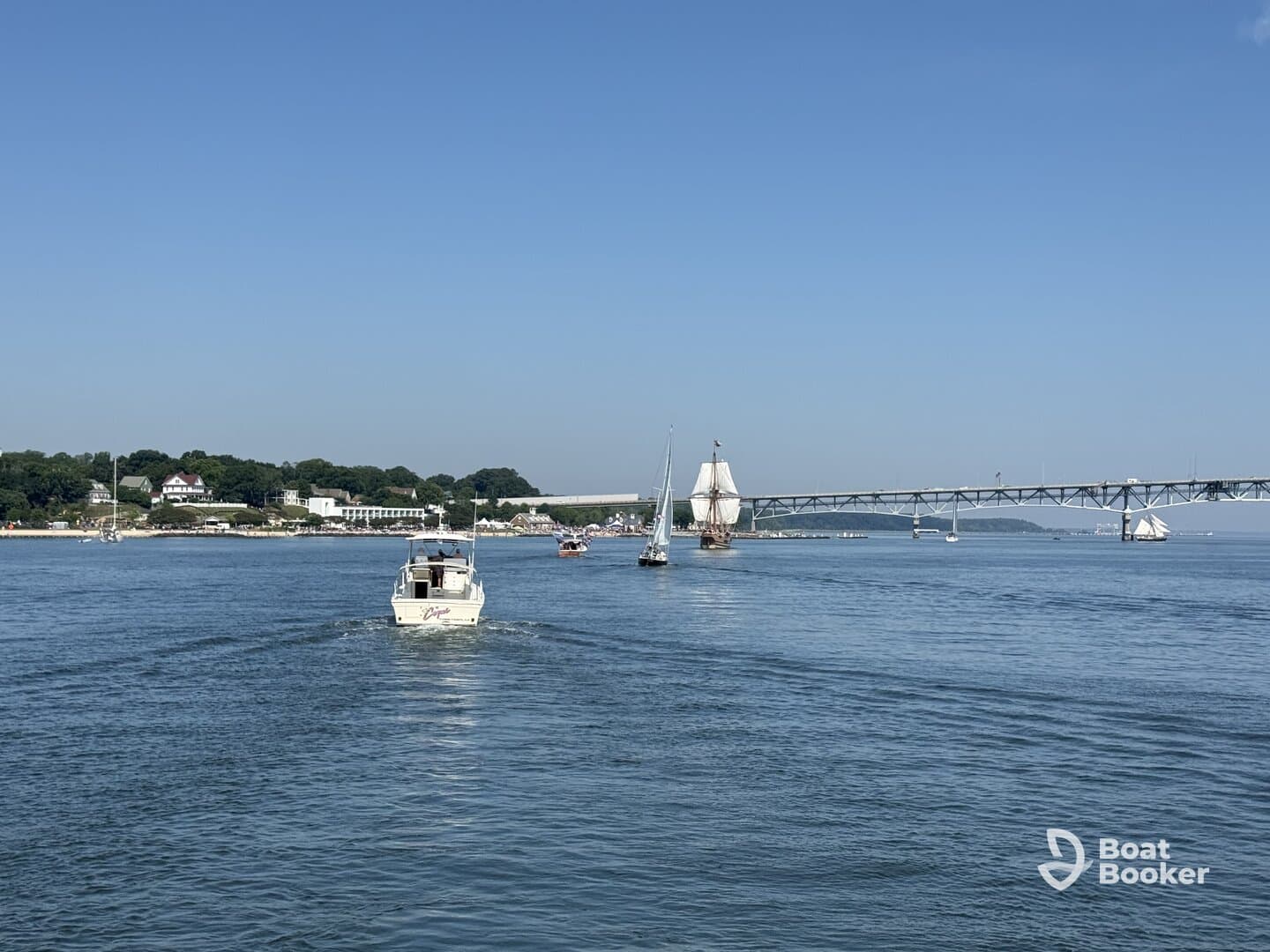 A scenic view of various boats sailing in a harbor, showcasing the beauty of a sunny day on the water.