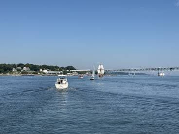 A scenic view of various boats sailing in a harbor, showcasing the beauty of a sunny day on the water.