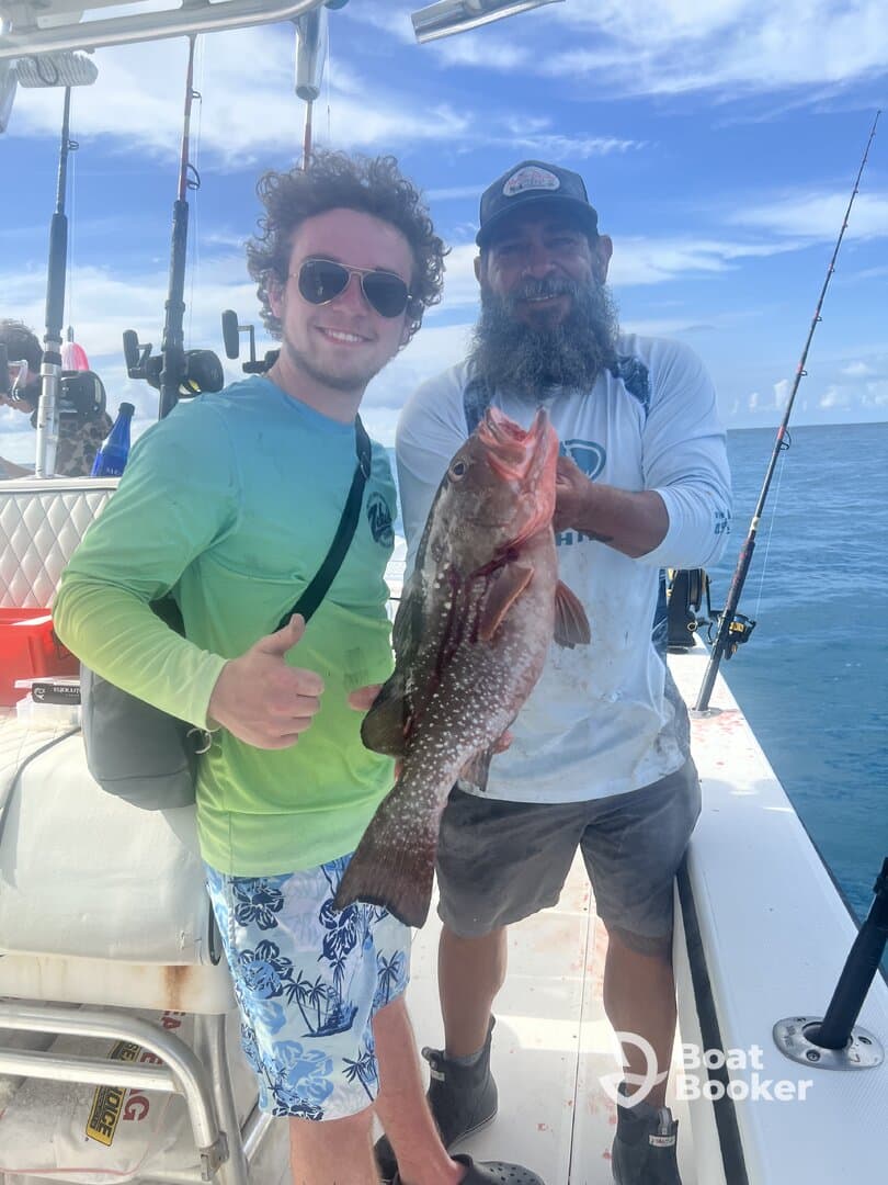 Two anglers proudly display their catch aboard a fishing boat, celebrating a successful day on the water. Perfect for fishing enthusiasts and adventure seekers.