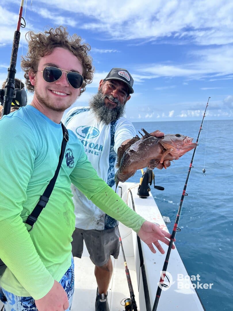 Two fishermen proudly display their catch on a fishing trip, showcasing the excitement of a successful day on the water.