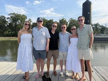 A cheerful group poses together on the dock, ready for a fun day on the water — perfect for gatherings and celebrations.