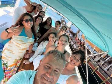 A joyful group of friends poses for a selfie aboard a boat, capturing the essence of fun and celebration on the water.