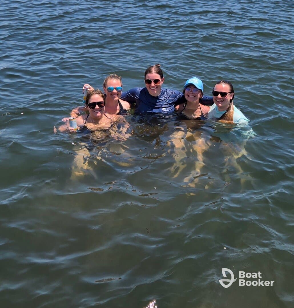 A group of friends enjoys a refreshing swim together in the water, capturing the essence of fun and camaraderie during their boating adventure.