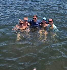 A group of friends enjoys a refreshing swim together in the water, capturing the essence of fun and camaraderie during their boating adventure.