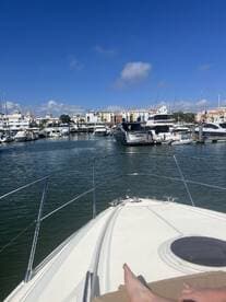 A scenic view from the bow of a boat in a marina, showcasing the vibrant cityscape and tranquil waters — perfect for exploring coastal destinations.