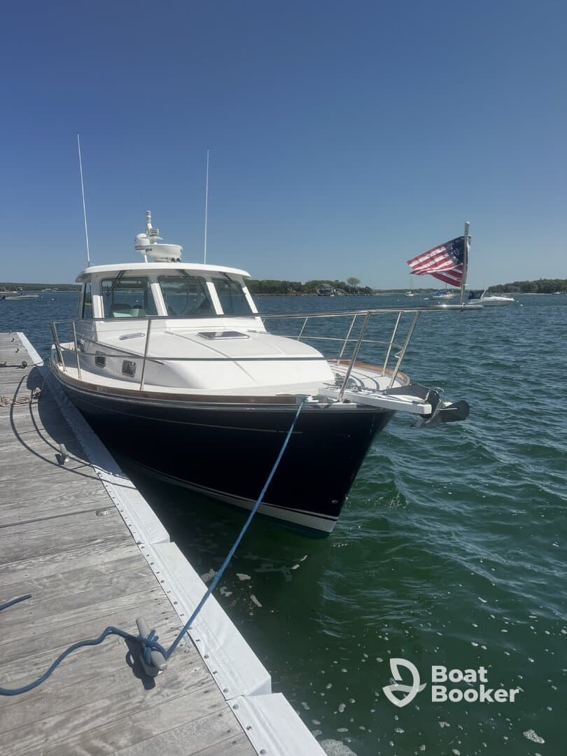 A beautiful yacht docked at the marina, showcasing its sleek design against a clear blue sky — perfect for summer outings on the water.