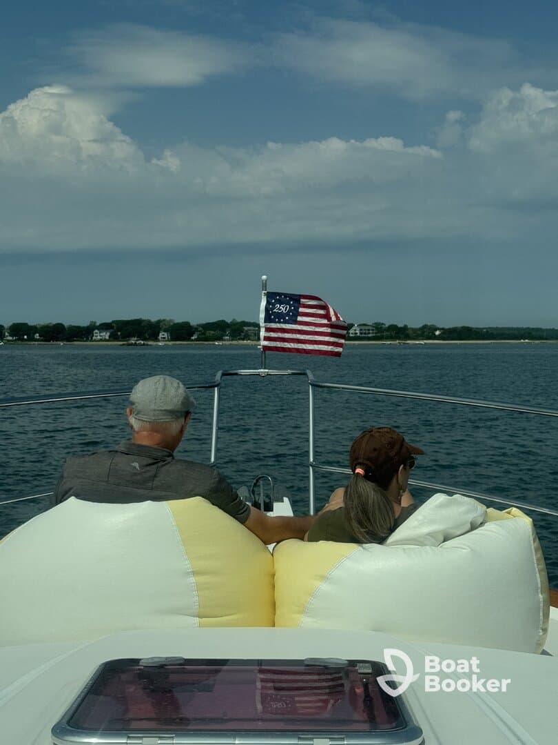 A couple enjoys a relaxing moment on a boat, taking in the scenic views of the water and shoreline. Perfect for romantic getaways or leisurely outings.