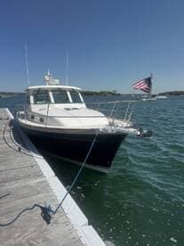 A beautiful yacht docked at the marina, showcasing its sleek design against a clear blue sky — perfect for summer outings on the water.