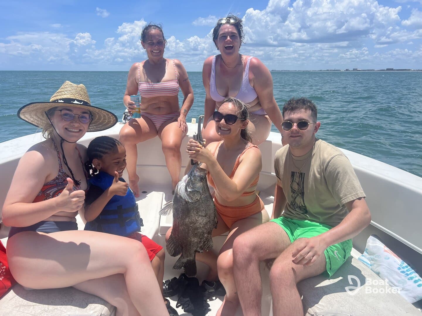 A joyful group celebrates a successful fishing trip on a boat, showcasing their catch and enjoying the sunny day on the water.