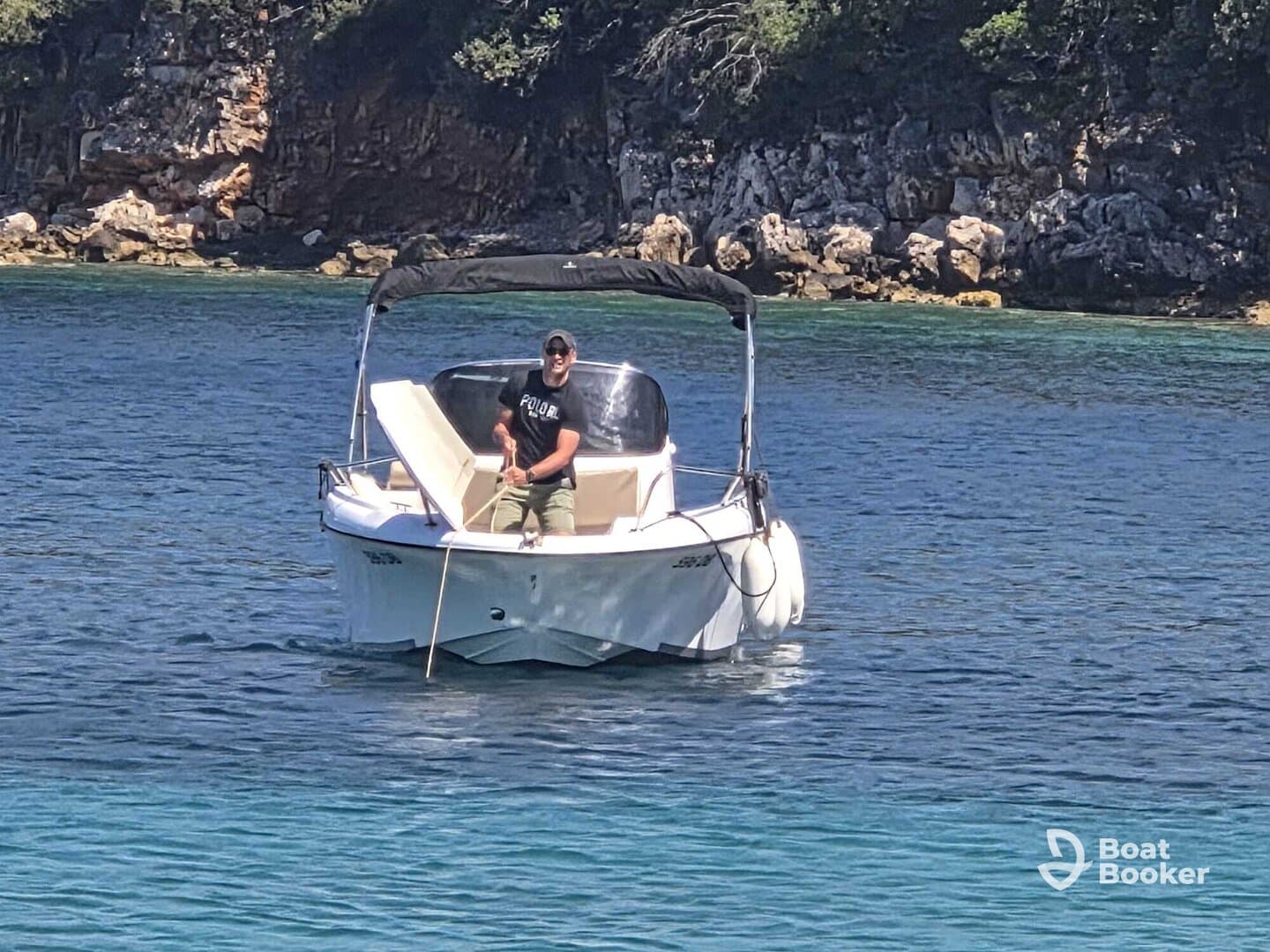 A man enjoys a day on the water, skillfully navigating his boat through crystal-clear waters, perfect for a relaxing boating experience.