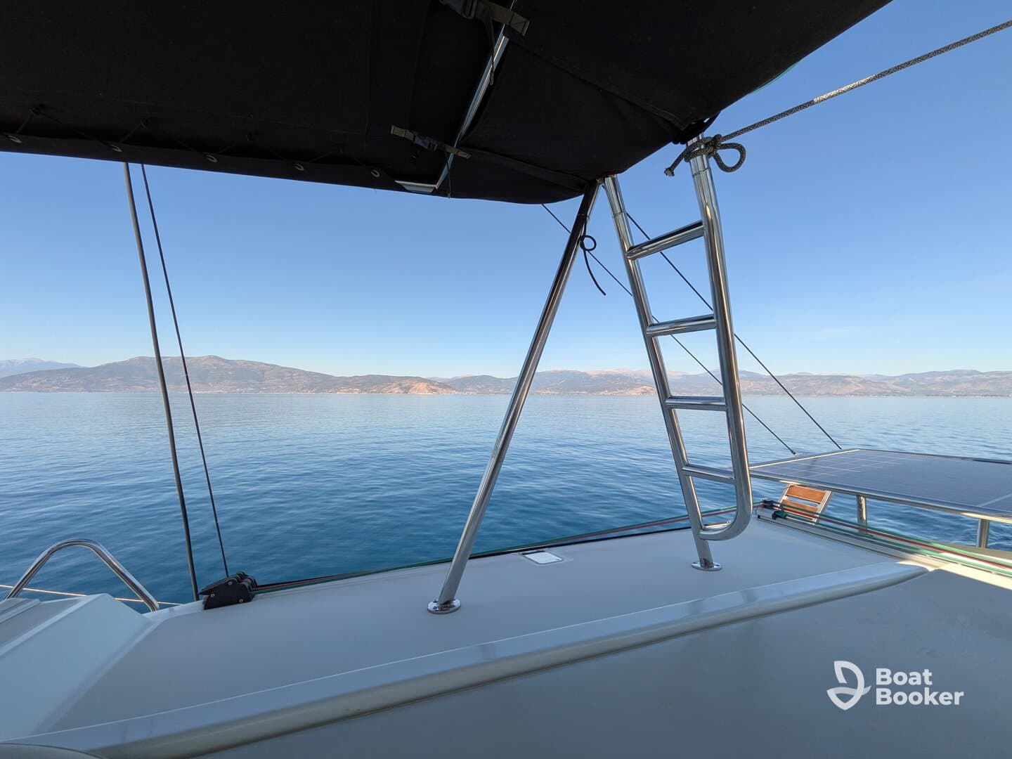 A serene view from the deck of a boat, showcasing the calm waters and distant mountains — perfect for peaceful cruising and relaxation.