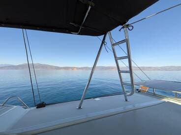 A serene view from the deck of a boat, showcasing the calm waters and distant mountains — perfect for peaceful cruising and relaxation.