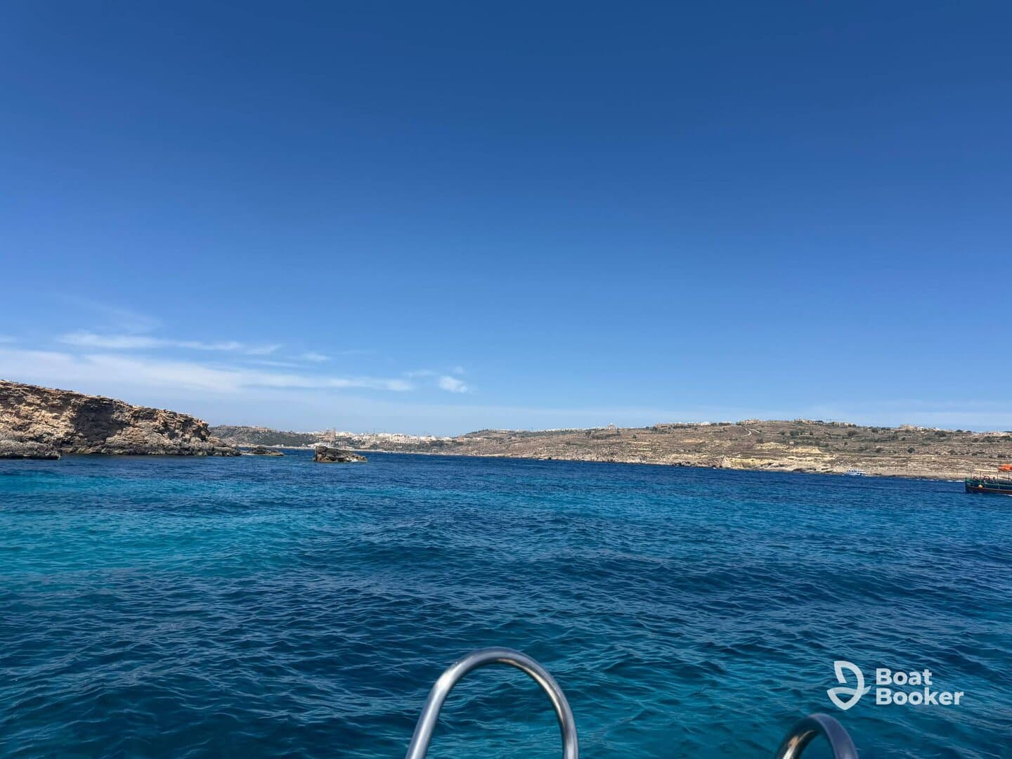 A stunning view of the coastline with crystal-clear blue waters, perfect for showcasing the beauty of a boating adventure.