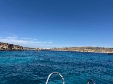A stunning view of the coastline with crystal-clear blue waters, perfect for showcasing the beauty of a boating adventure.