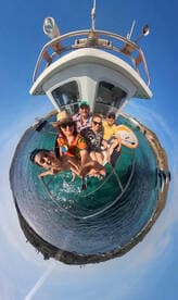A joyful group of friends and family take a selfie on a boat, capturing their fun day out on the water — perfect for memorable boating adventures.
