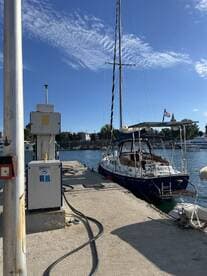A beautiful yacht docked at the marina, showcasing its elegant design against a clear blue sky. Perfect for those looking to explore the waters.