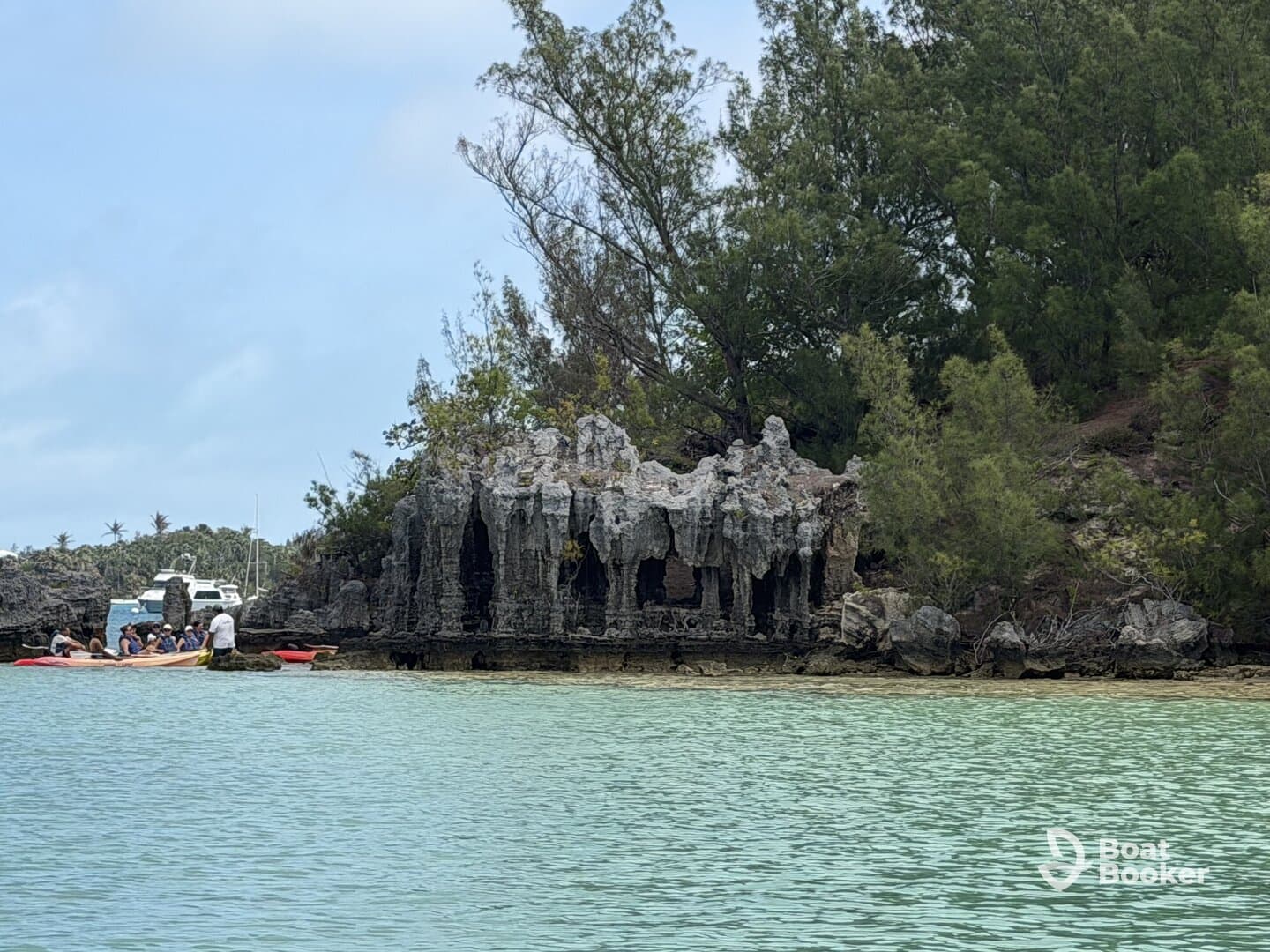 A group of adventurers enjoys kayaking near stunning rock formations in a serene lagoon, showcasing the beauty of island exploration.