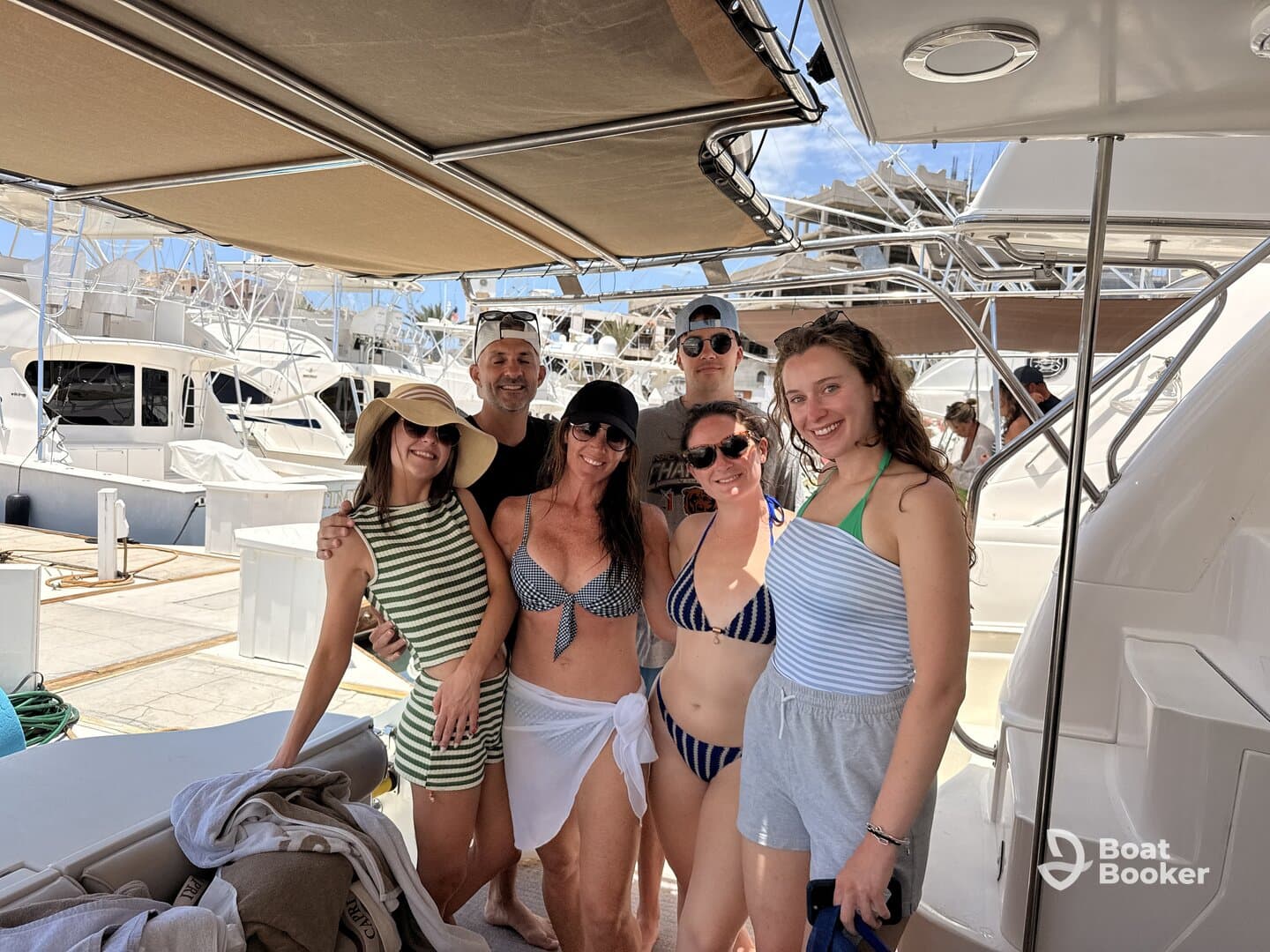 A cheerful group of friends poses for a photo on a boat, enjoying a sunny day together — perfect for memorable outings and celebrations on the water.