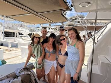 A cheerful group of friends poses for a photo on a boat, enjoying a sunny day together — perfect for memorable outings and celebrations on the water.