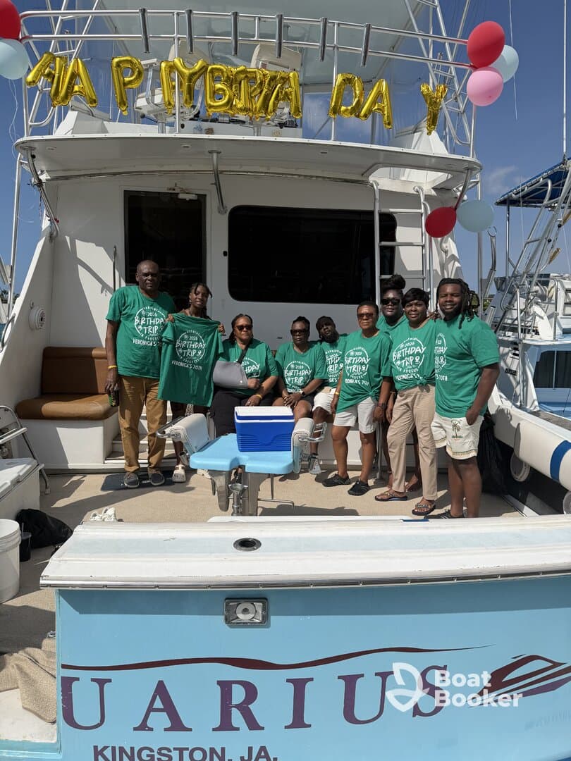 A joyful group celebrates a birthday trip aboard a boat, showcasing their matching shirts and festive decorations — perfect for memorable celebrations on the water.