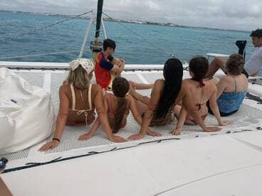 A group of friends enjoys a relaxing moment on a catamaran, taking in the beautiful ocean views — perfect for a day of fun and adventure on the water.
