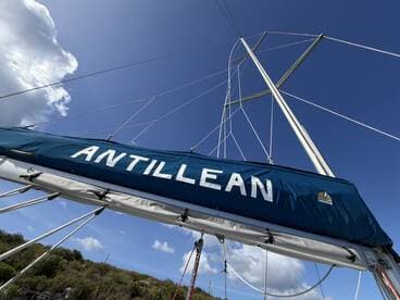 A close-up view of the sailboat 'Antillean' showcasing its mast against a vibrant blue sky, perfect for sailing enthusiasts and maritime photography.