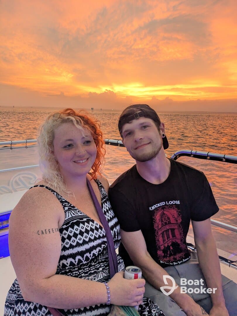 A couple enjoys a romantic sunset on a boat, capturing the perfect moment with drinks in hand — an ideal setting for memorable celebrations on the water.
