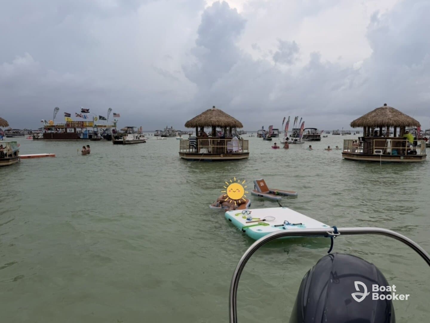 Guests enjoy a lively sandbar stop with various boats and activities in the background, perfect for a fun day on the water.