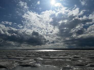 A scenic view of a cloudy sky reflecting on a water surface, creating a serene atmosphere. Ideal for nature lovers and photography enthusiasts.