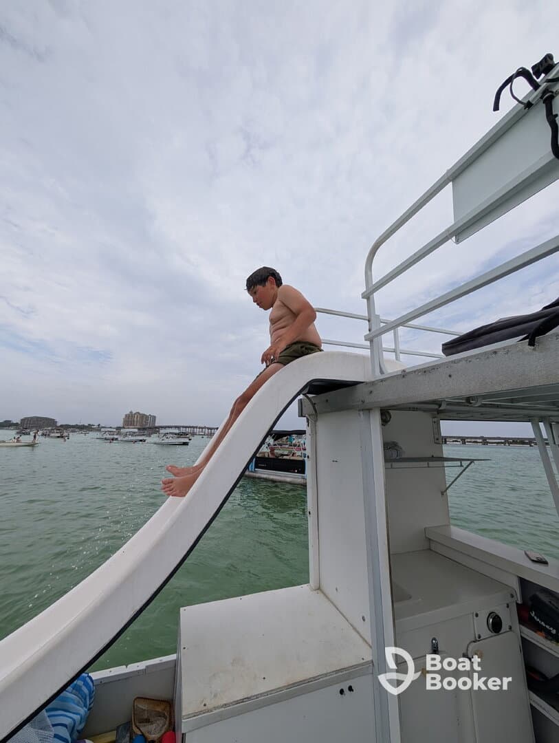A child prepares to slide into the water from a boat, capturing the excitement of summer fun on the water.