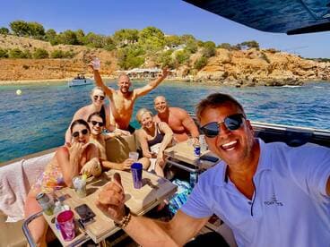 A joyful group of friends enjoys a sunny day on the water, celebrating with drinks and laughter aboard a boat — the perfect backdrop for unforgettable summer memories.