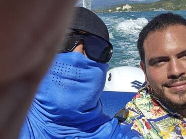 Two friends take a selfie while enjoying a boat ride, capturing the thrill of their adventure on the water.