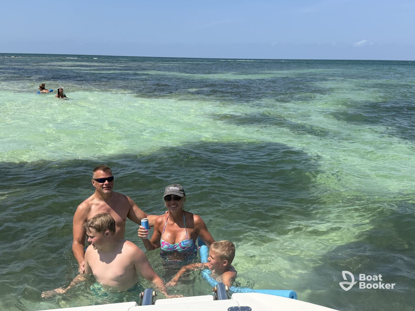 A joyful family enjoys a sunny day swimming in clear waters, creating unforgettable memories together in a tropical paradise.
