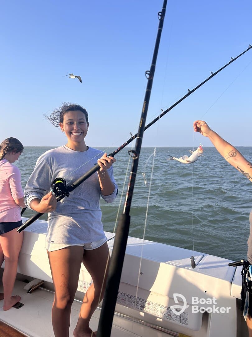 A joyful fishing experience on the open water, showcasing friends catching fish and enjoying the day under a clear blue sky.
