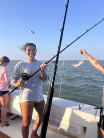 A joyful fishing experience on the open water, showcasing friends catching fish and enjoying the day under a clear blue sky.