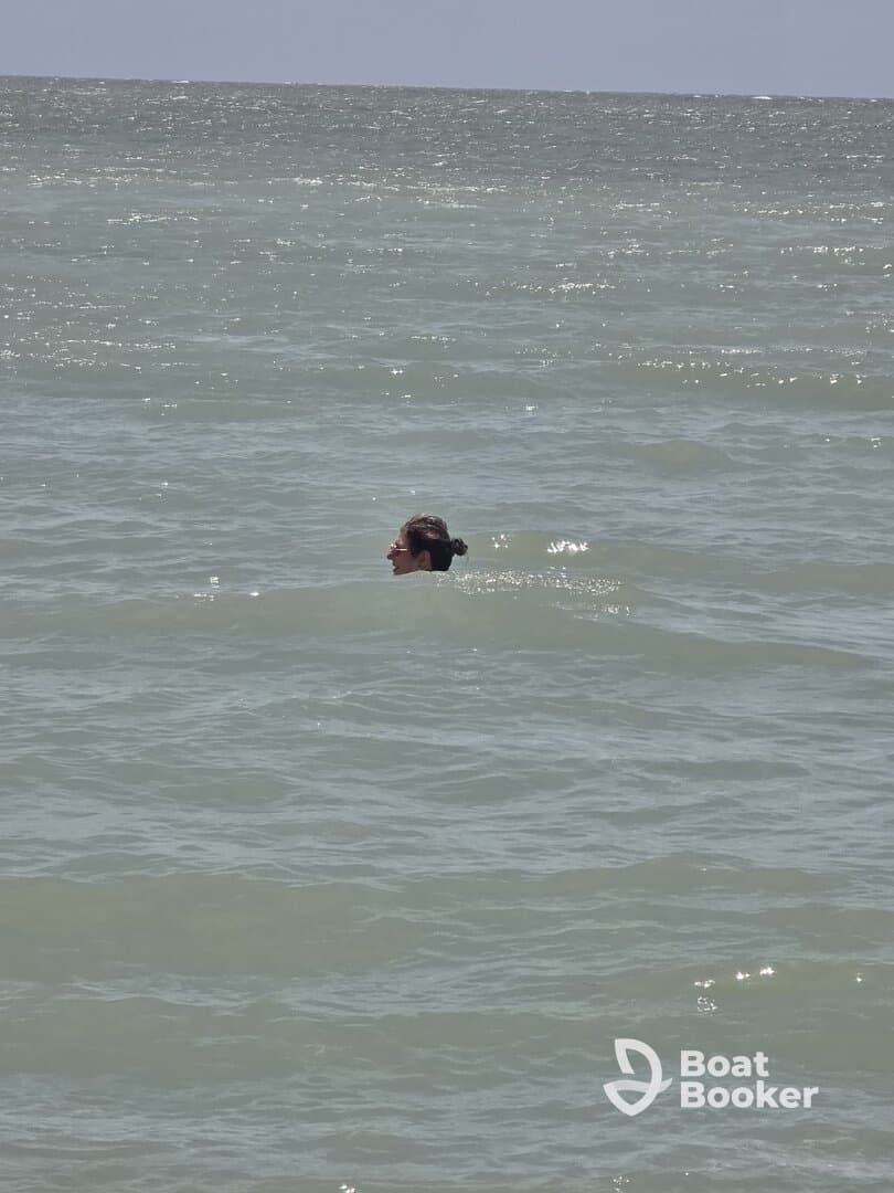 A person enjoys a refreshing swim in the ocean, capturing the essence of a perfect day on the water.