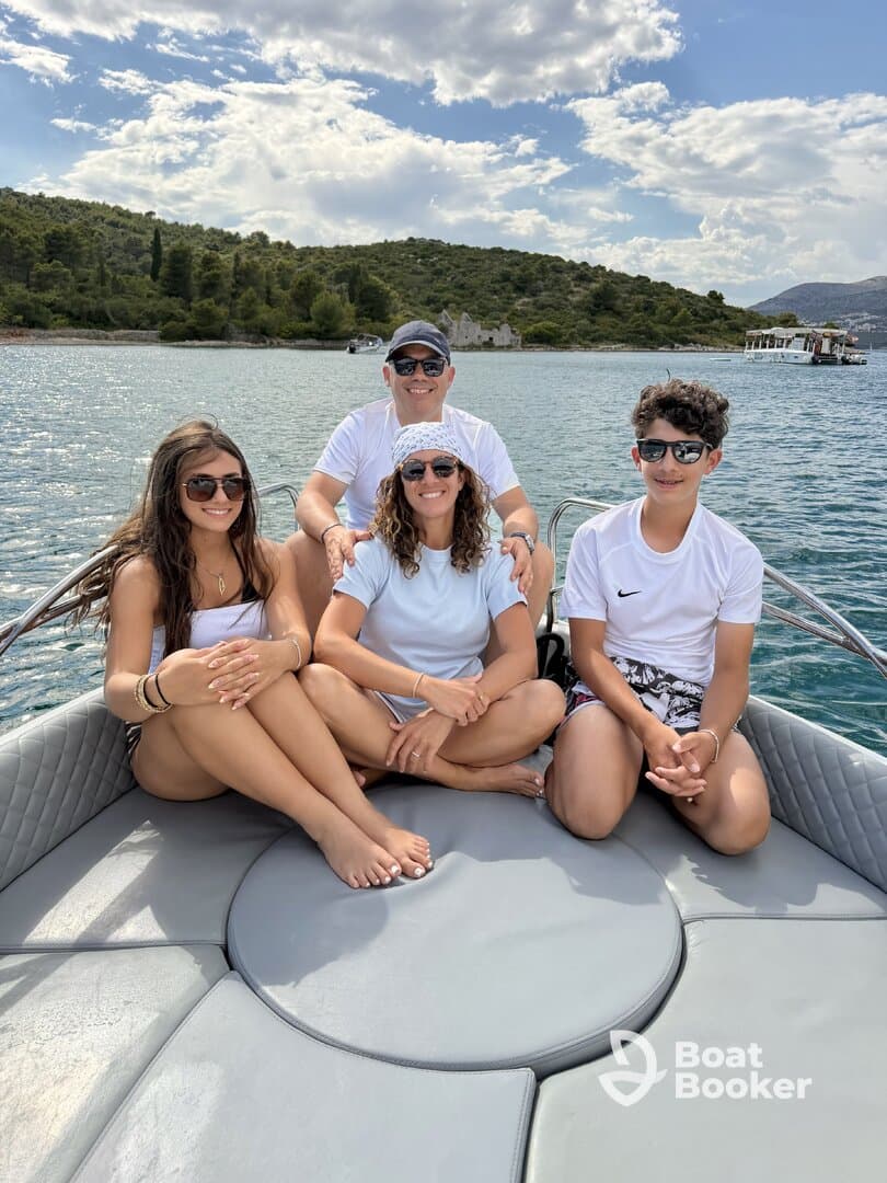 A cheerful family enjoys a sunny day on a boat, capturing memorable moments together against a picturesque backdrop of nature.