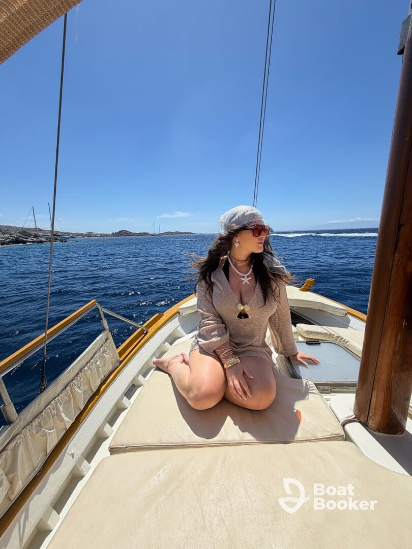 A woman enjoys a sunny day on the deck of a boat, capturing the essence of relaxation and adventure on the water.