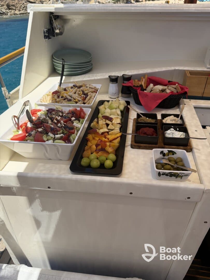 A beautifully arranged spread of fresh salads and fruits on a boat, perfect for catering during a day on the water.