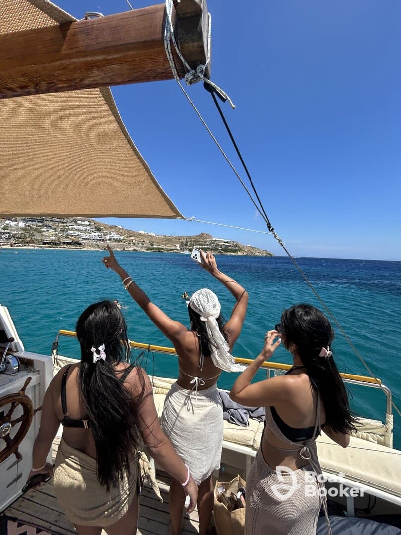 A lively group of friends enjoys a sunny day on a boat, celebrating and taking in the beautiful ocean views — perfect for summer adventures and memorable outings.